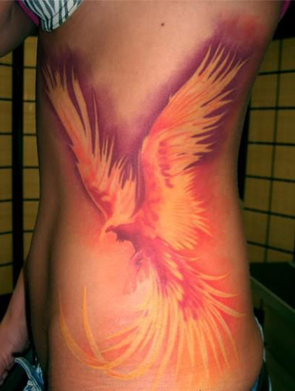 феникс с распахнутыми крыльями - татуировка на боку